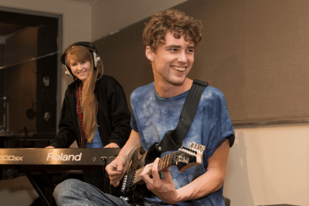 Male and female jamming on guitar and keyboard