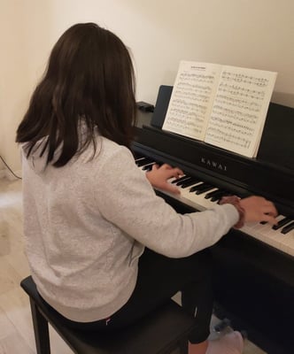 Lucy playing her new piano