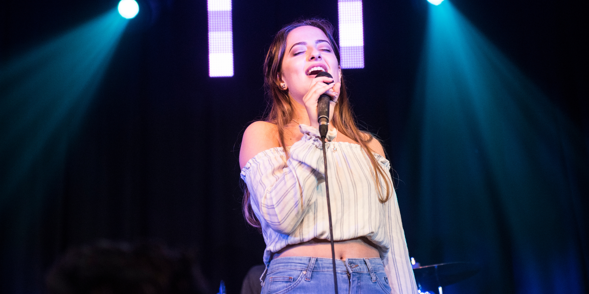 Girl singing on stage with microphone