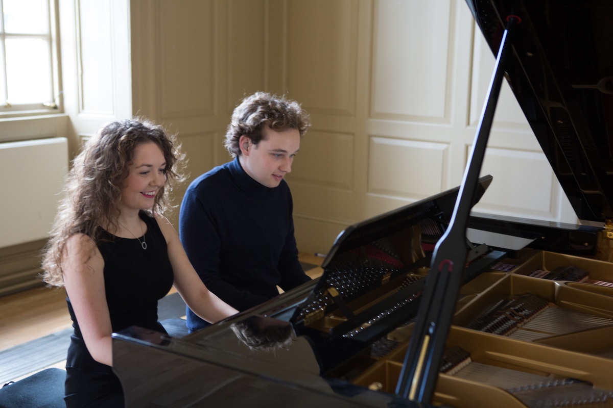 Male and female duetting on a piano