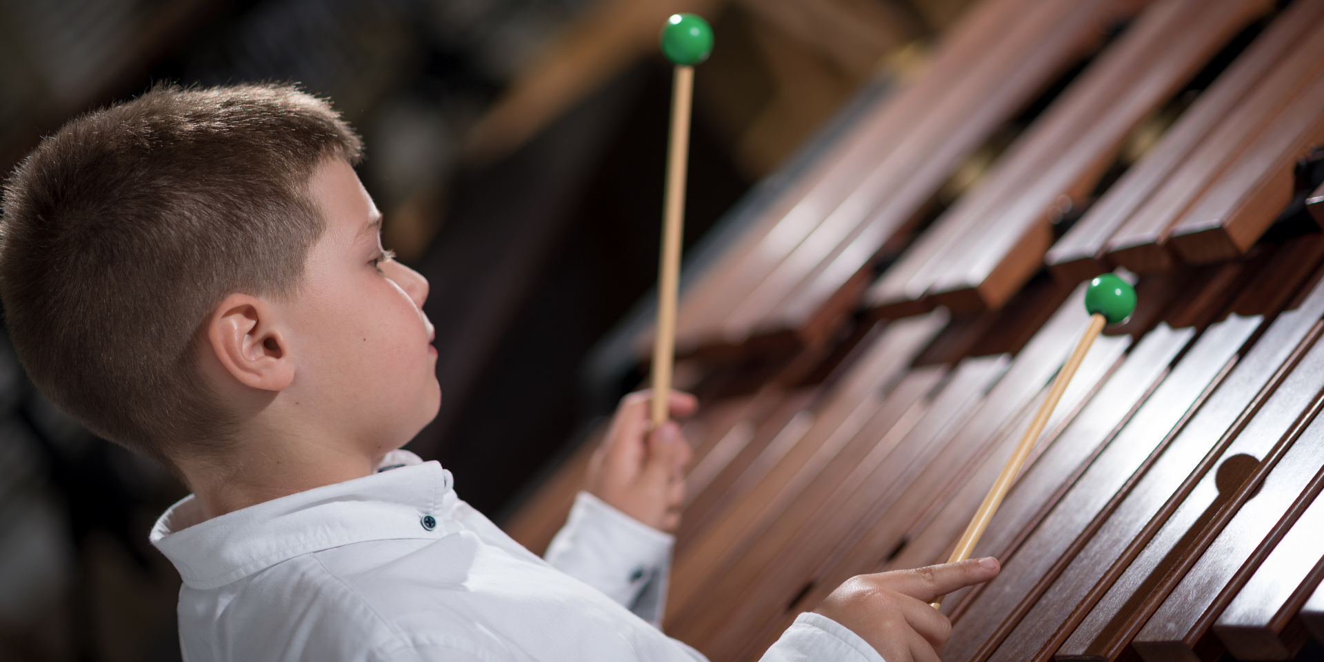 Young boy playing a xylophone with beaters