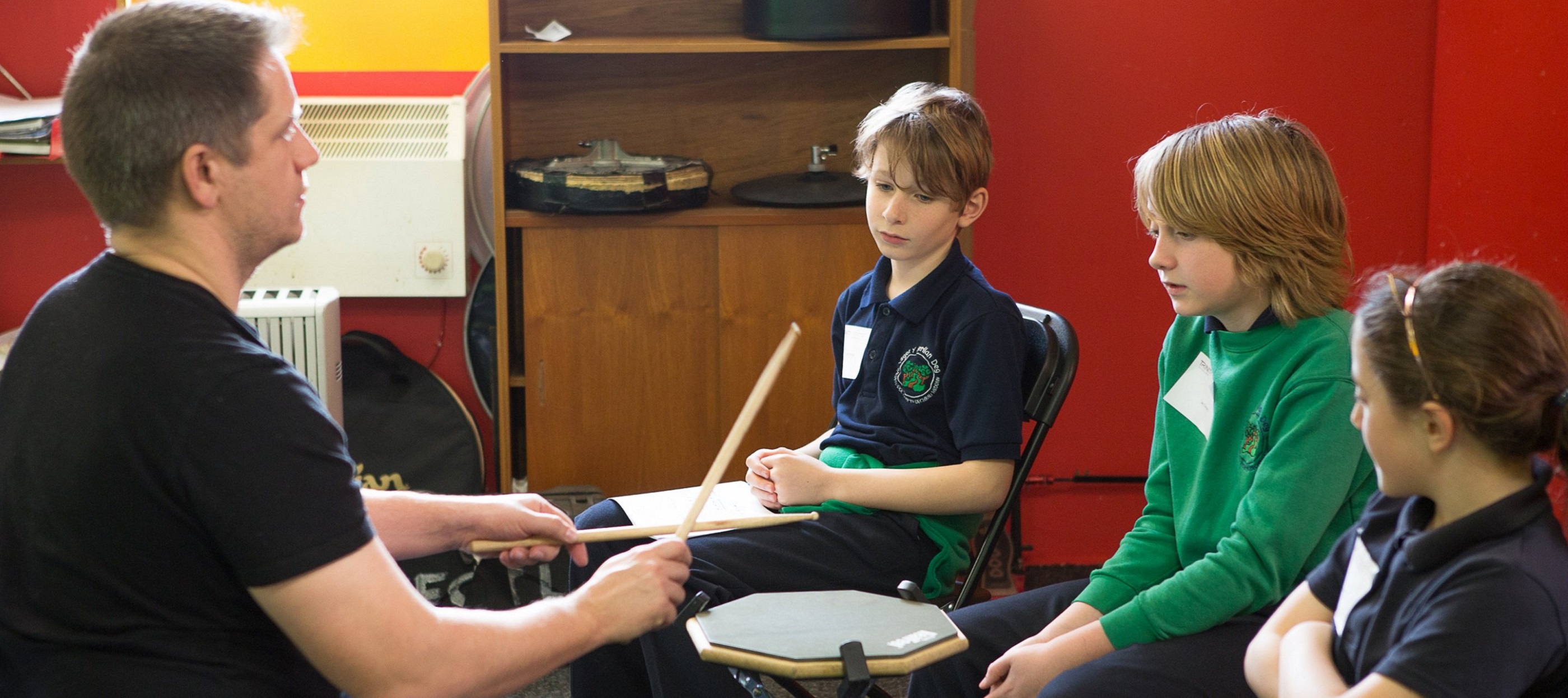 Drum teacher with small group of primary aged students